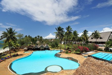 Blick über Pool- und Gartenlandschaft zum Strand im Hotel The Reef