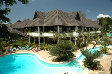 Pool und Restaurant im tropischen Garten des Travellers Beach & Club