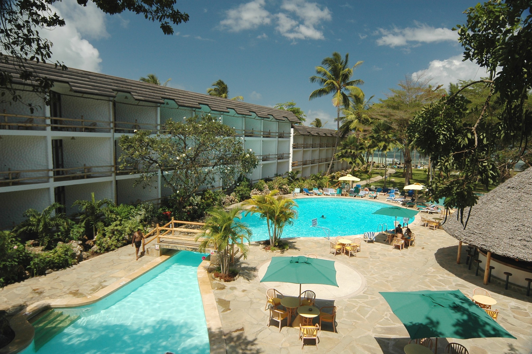 Poolbereich mit Blick zum Meer und den Zimmern im Travellers Beach Hotel