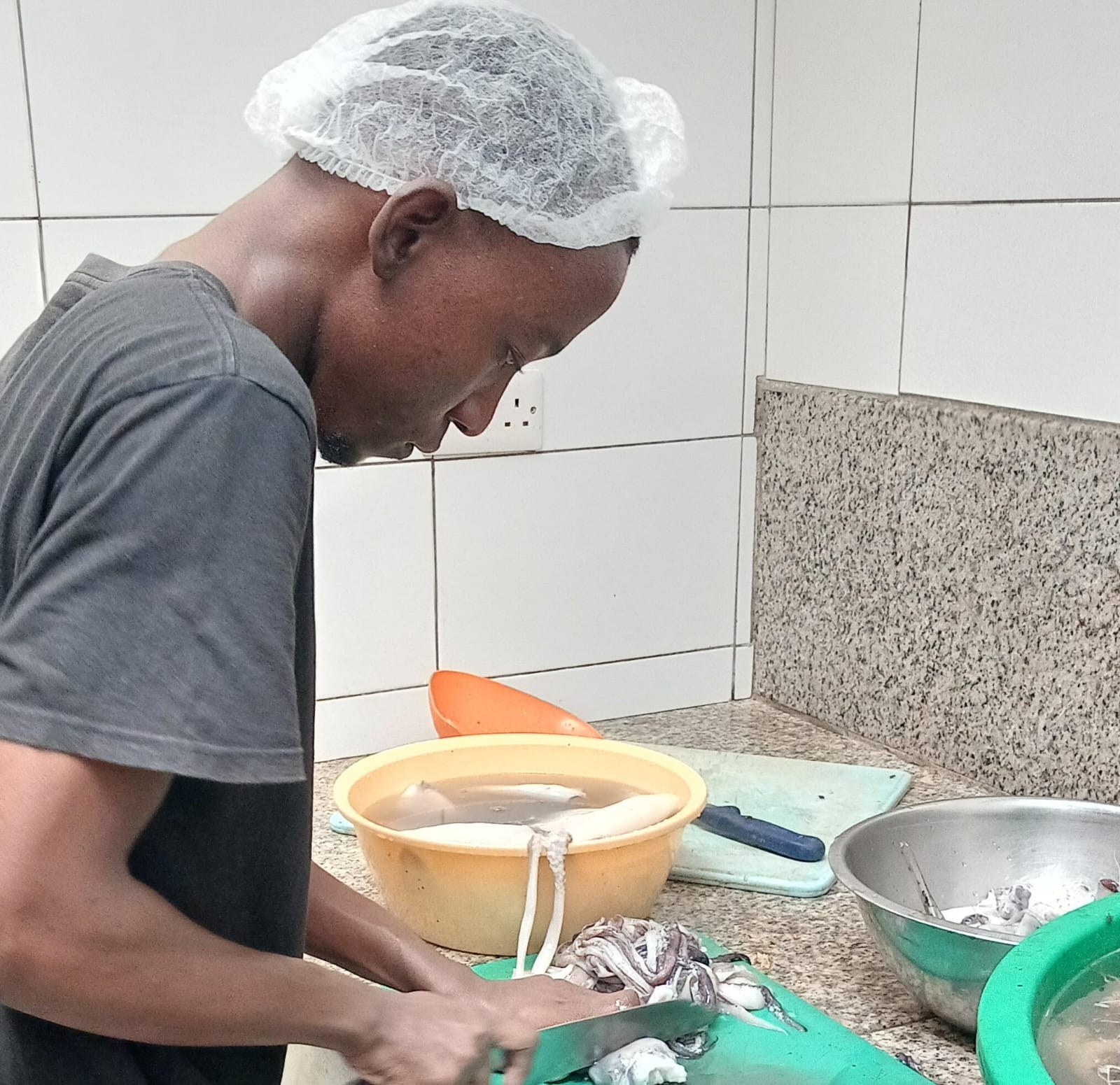 Kazungu bei der Zubereitung von Calamari während seiner Kochausbildung in Kenia